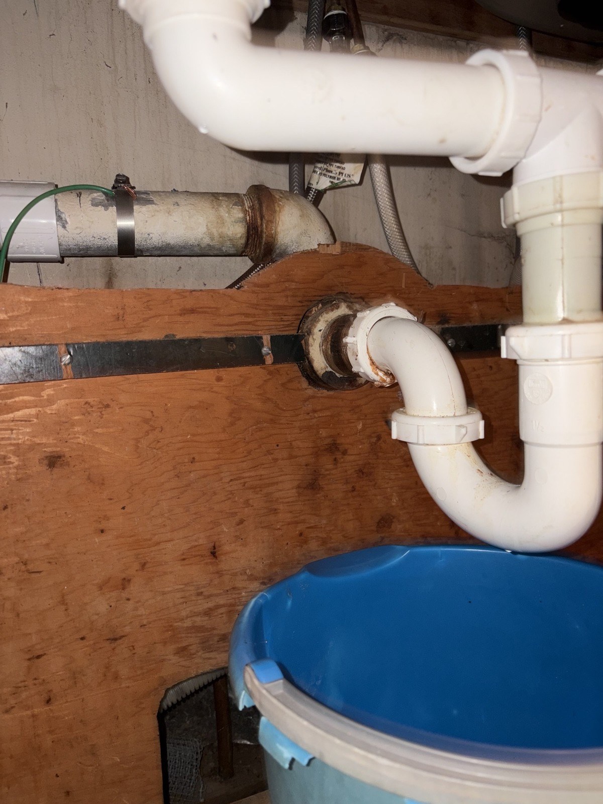 Under-sink drain assembly in a Lynnwood kitchen with a corroded galvanized nipple at the wall connection